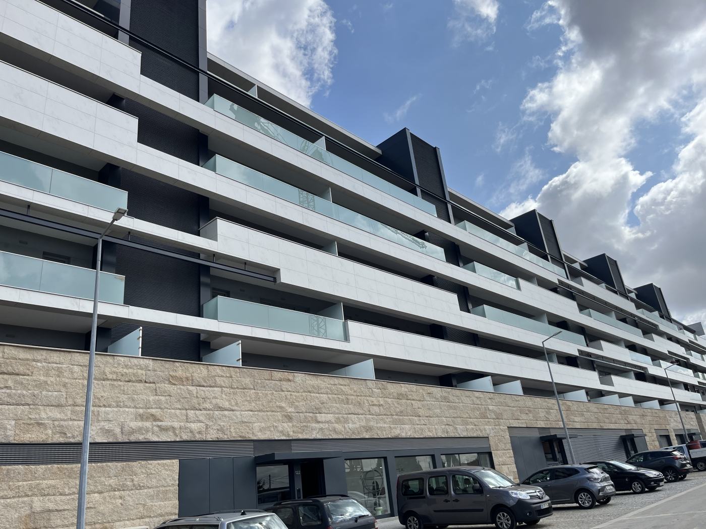 Detalhe de varandas e vegetação em edifício residencial Altavista